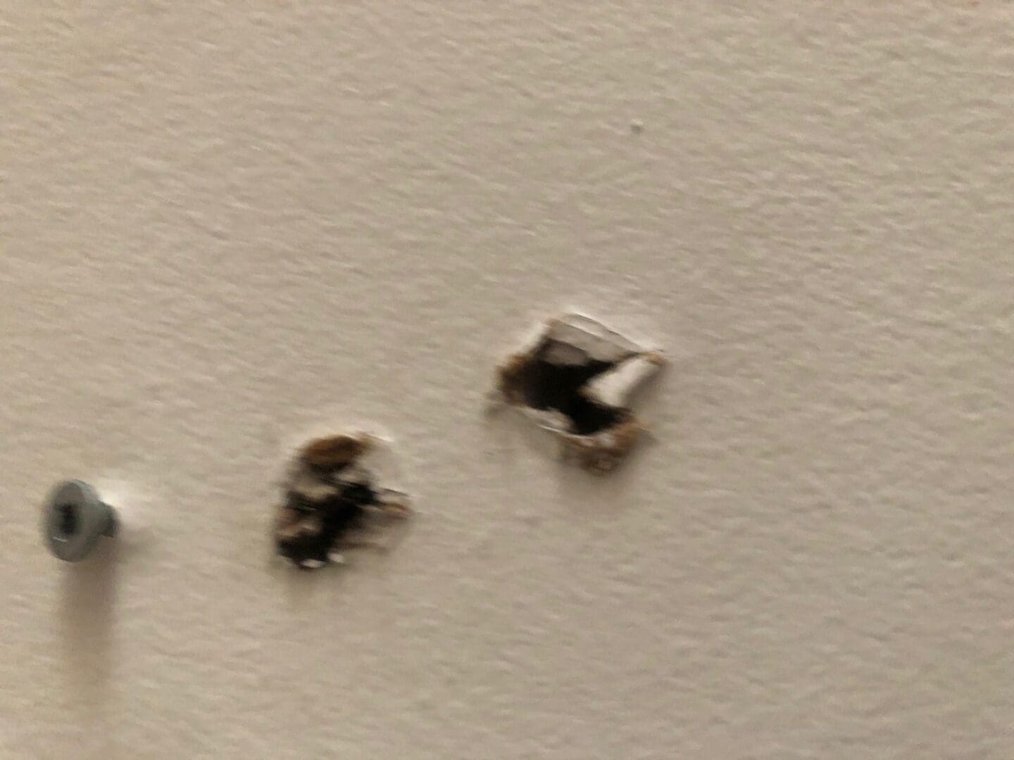 A wall with holes in it and two small ones on the side.