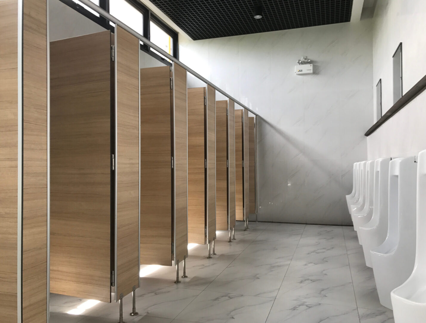 A row of wooden stalls in a bathroom.