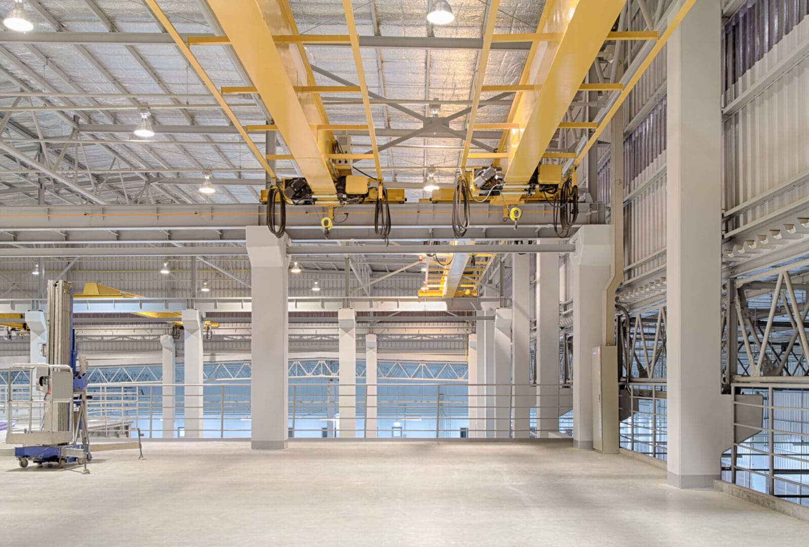 A large warehouse with yellow beams and white walls.