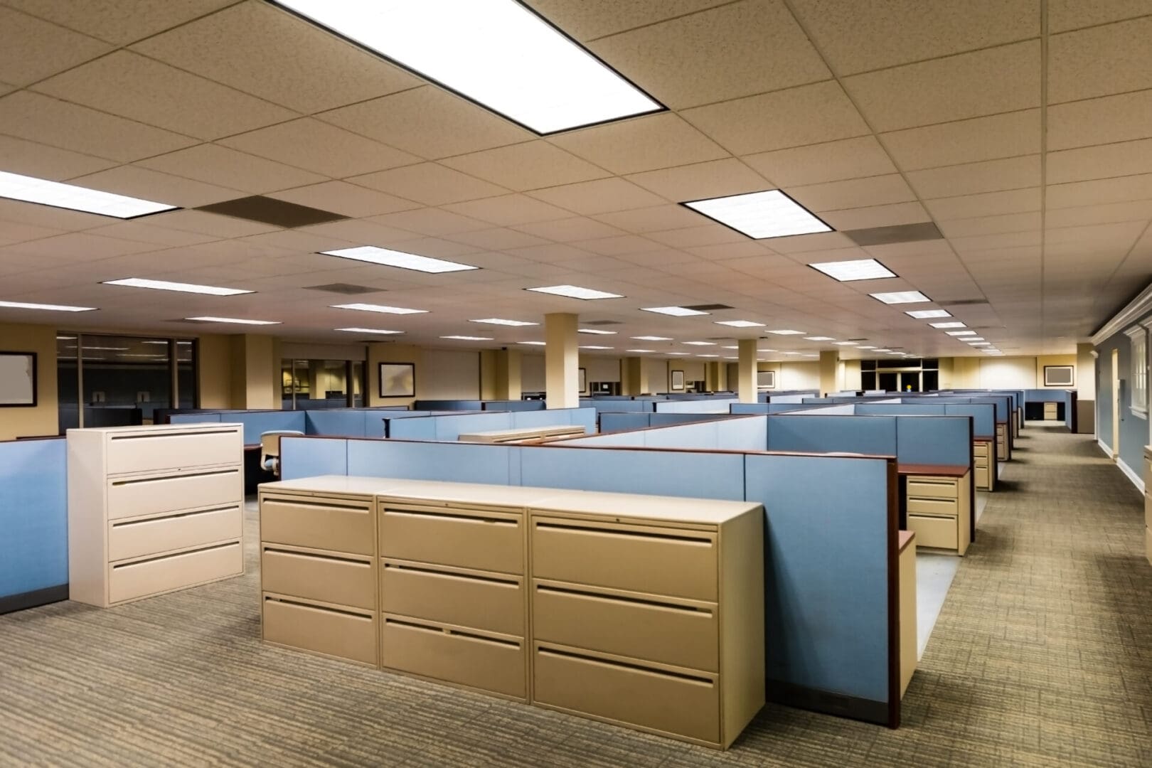 A large office with many desks and some lights