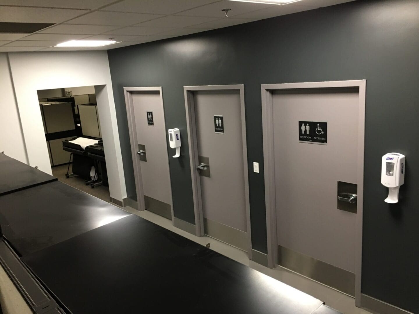 A row of three doors in a room.