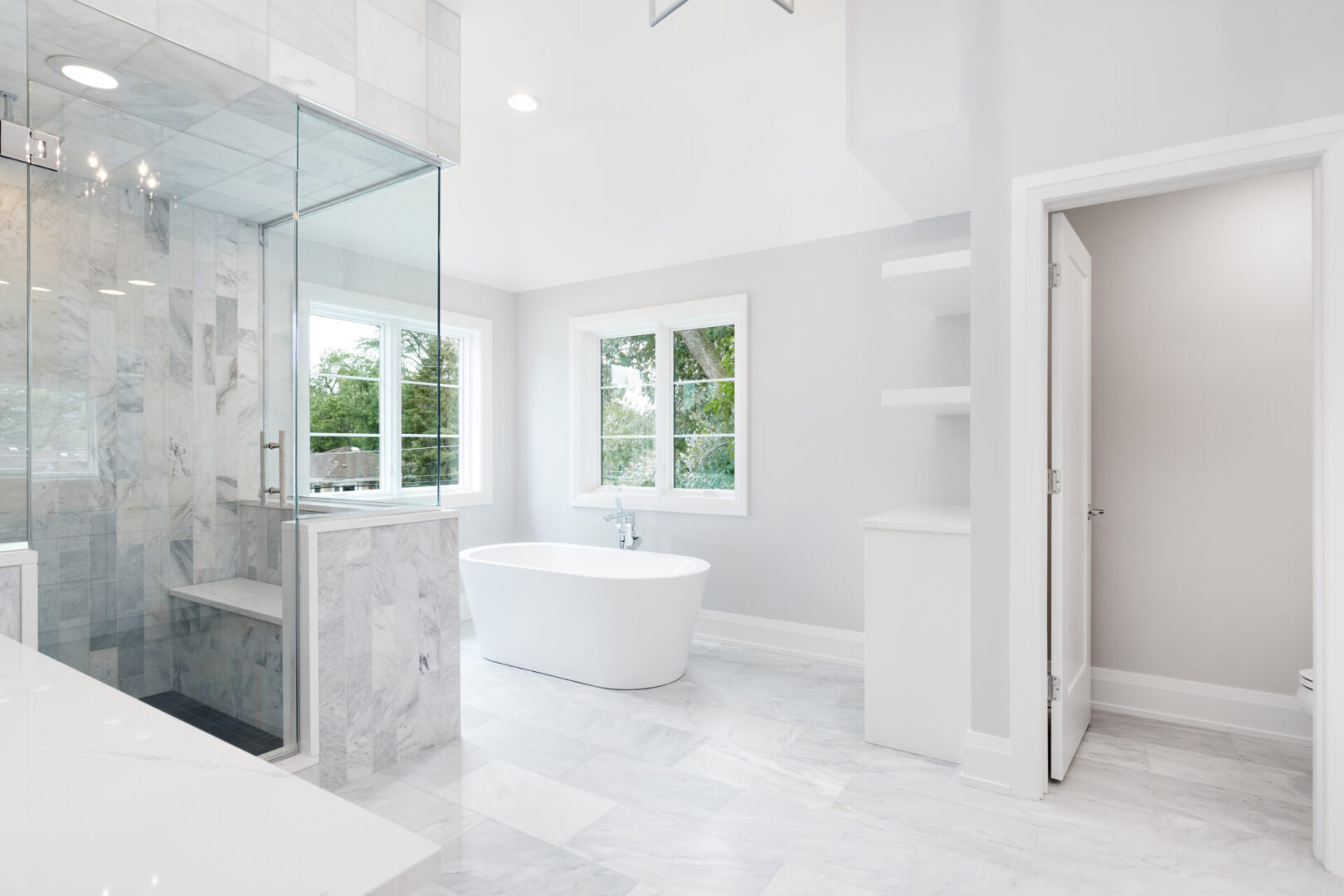 A white bathroom with a large tub and walk in shower.