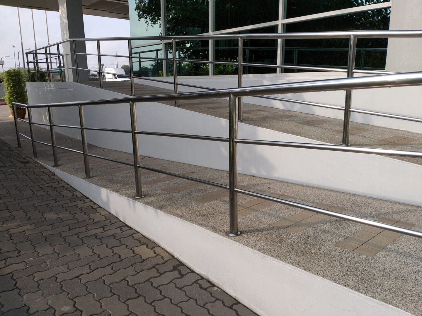 A walkway with metal railing and steps leading to the top.