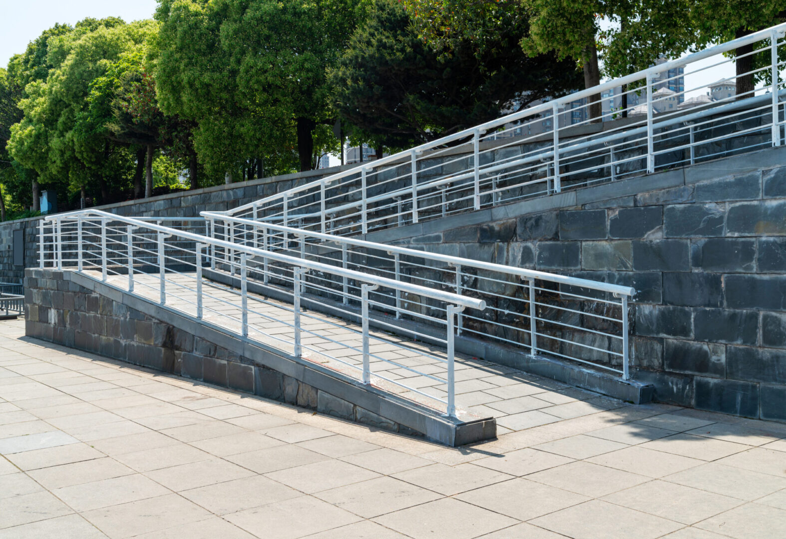 A concrete walkway with metal railing and steps.