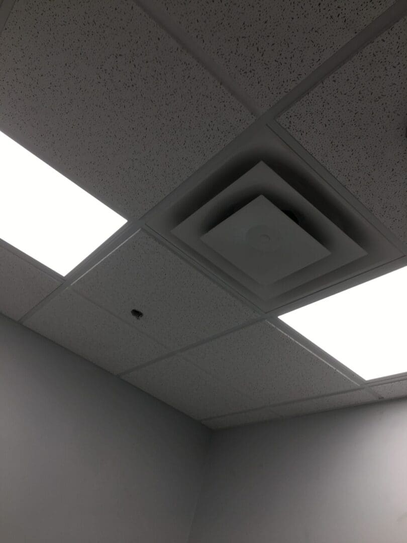 A ceiling with two vents in the middle of it.