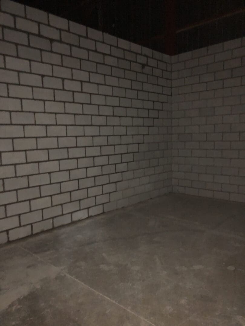 A room with white brick walls and concrete floors.