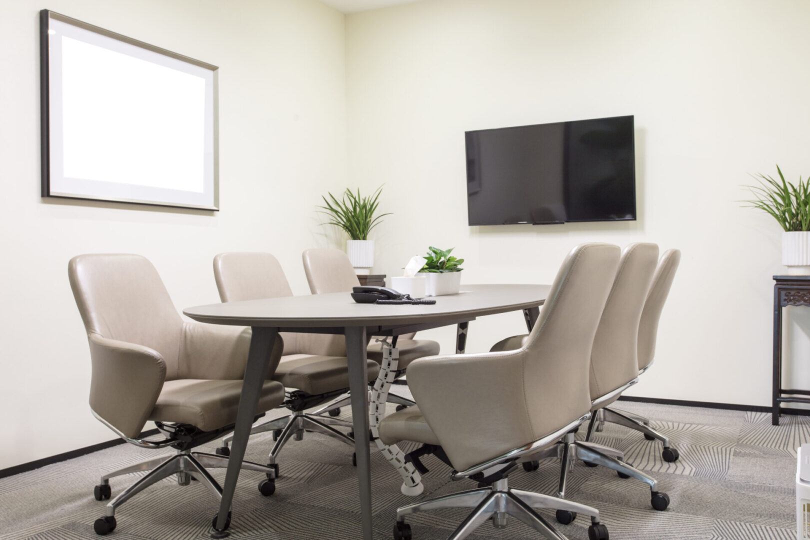 A conference room with white chairs and a table.