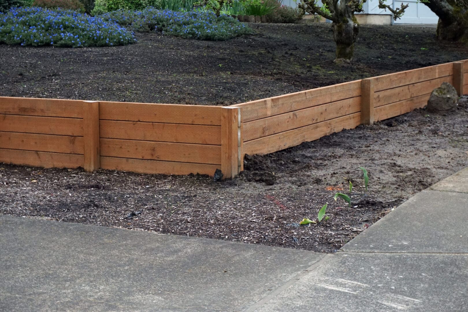 A wooden fence in the middle of a yard.