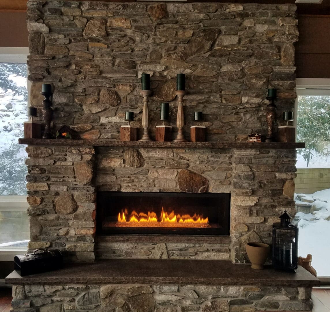 A stone fireplace with a fire burning in it.