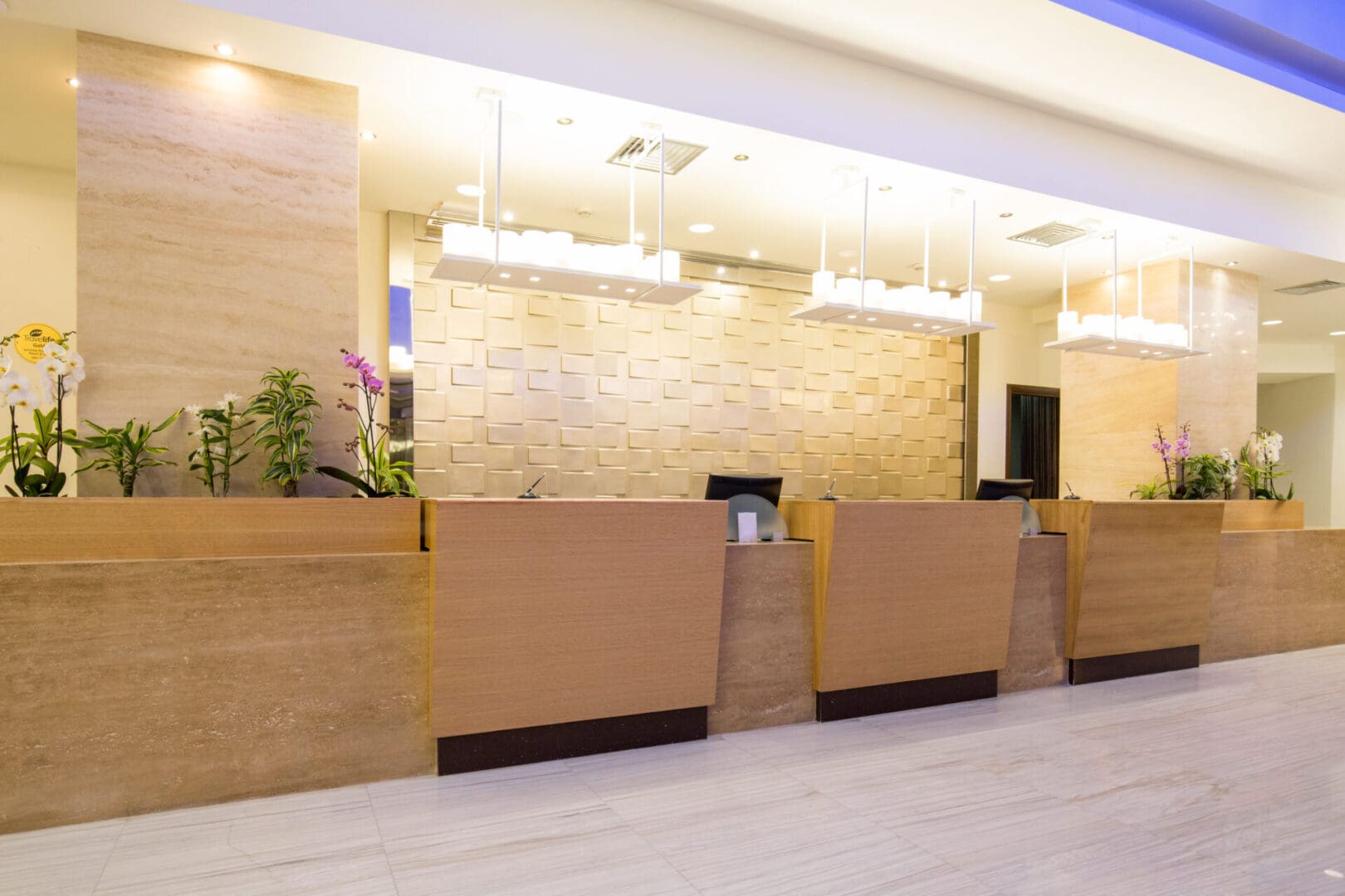 A hotel lobby with a large reception desk.