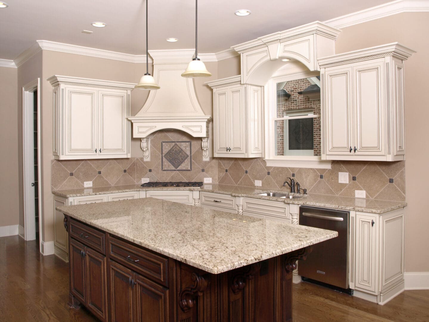 A kitchen with white cabinets and brown island.