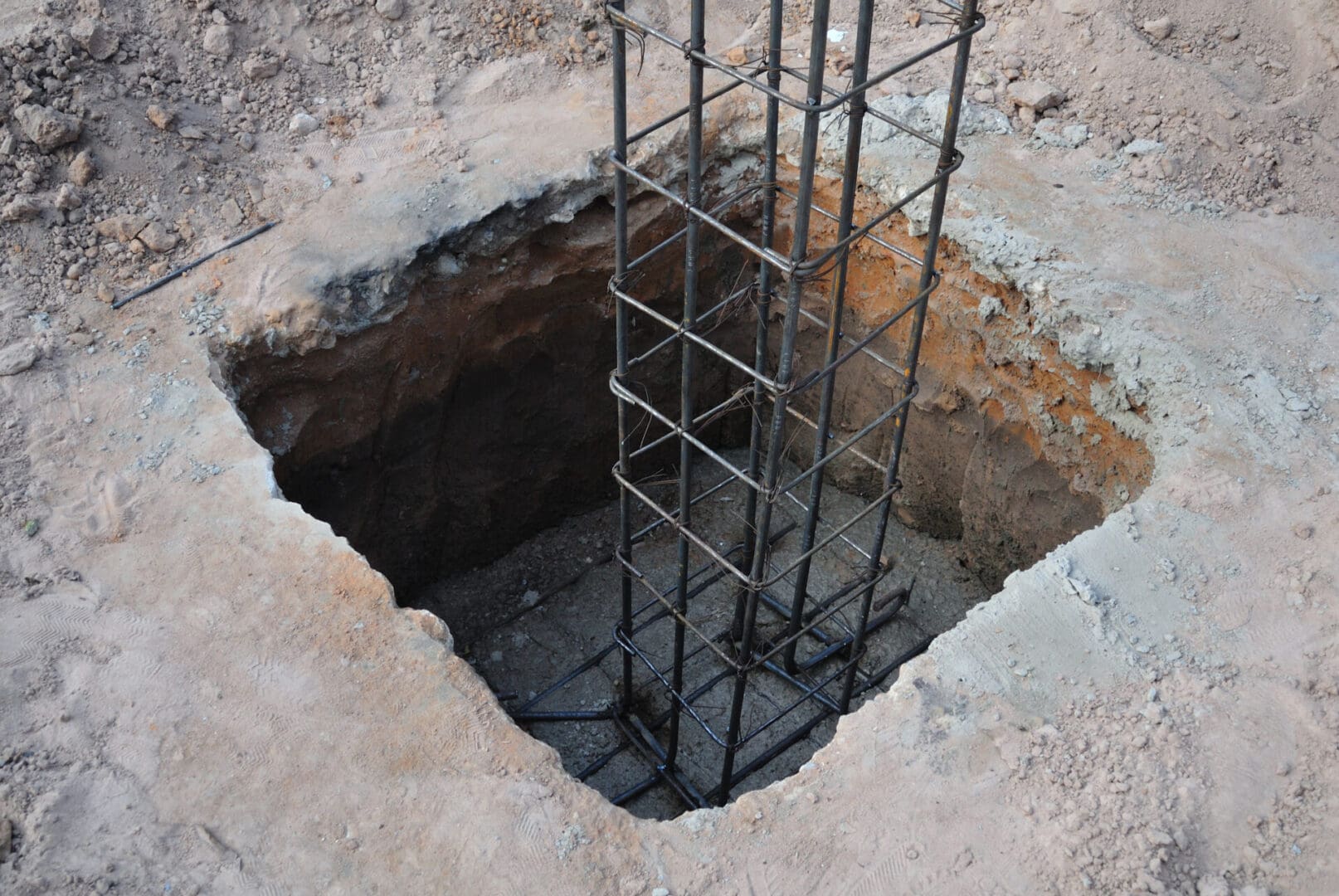 A hole in the ground with metal bars around it.