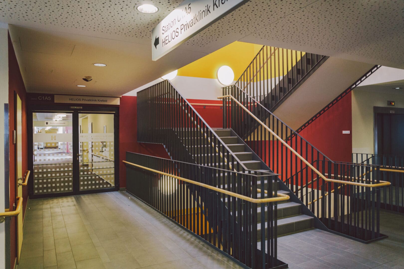 A staircase with black railings and yellow steps.