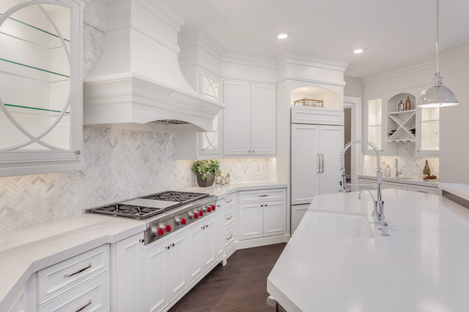 A kitchen with white cabinets and marble countertops.