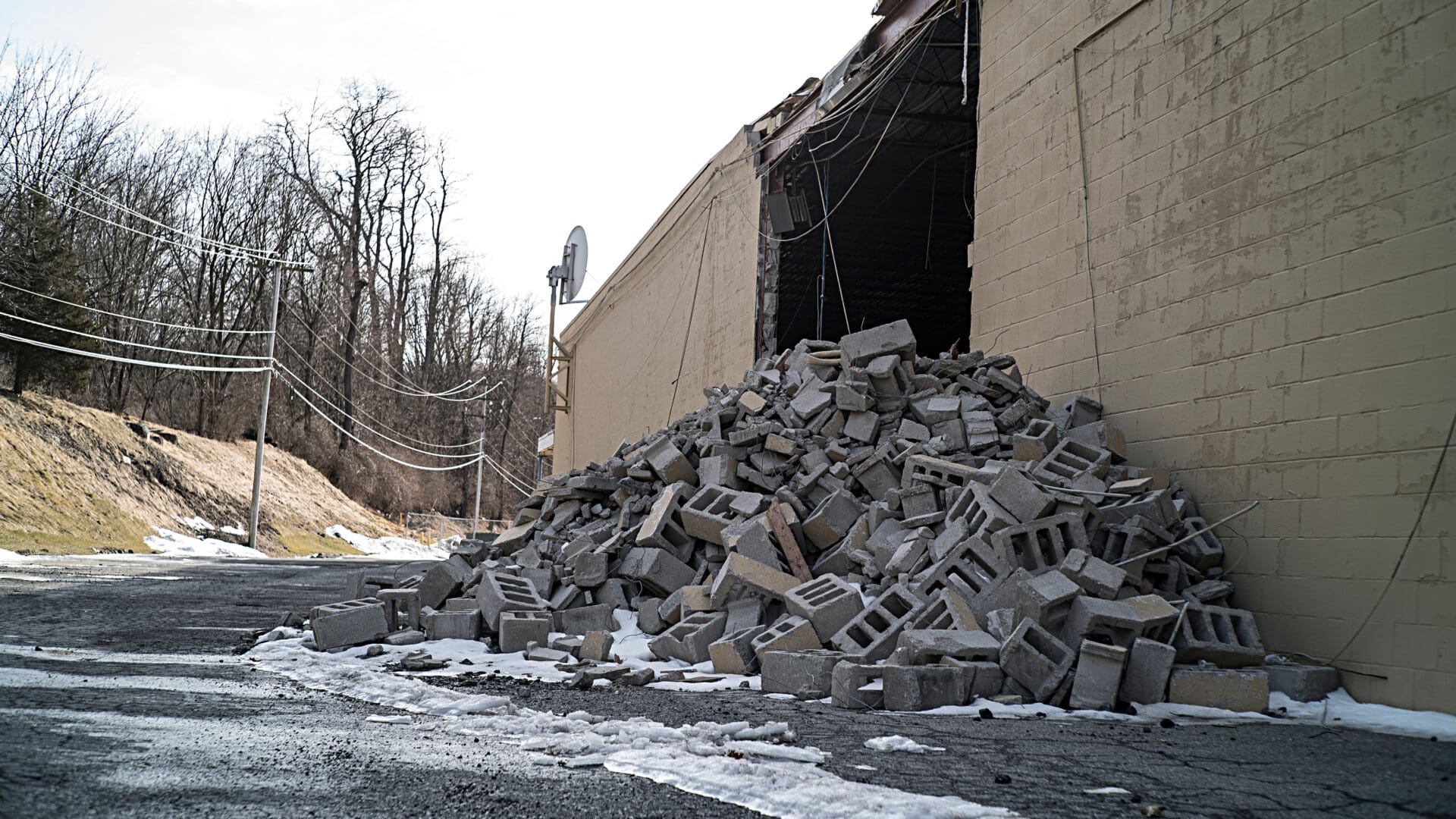 A pile of rubble is piled up against the side of a building.