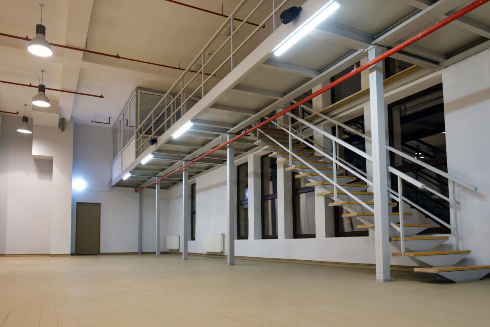 A large room with stairs and lights on the ceiling.