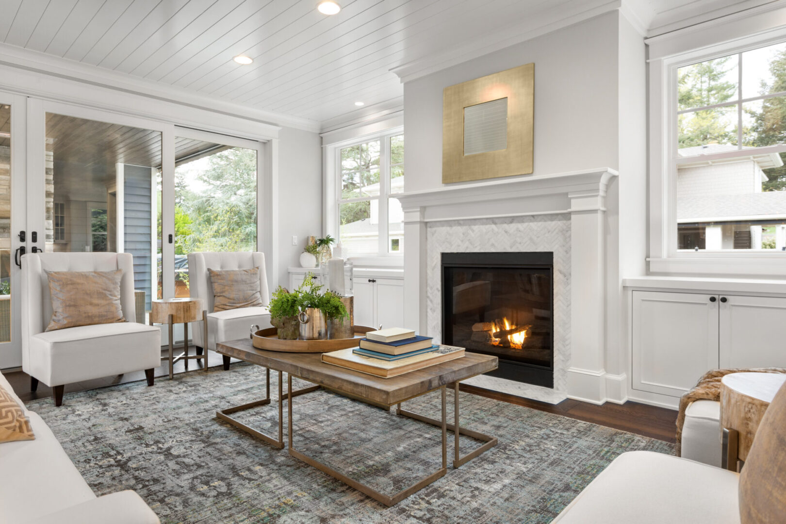 A living room with a fireplace and white walls.