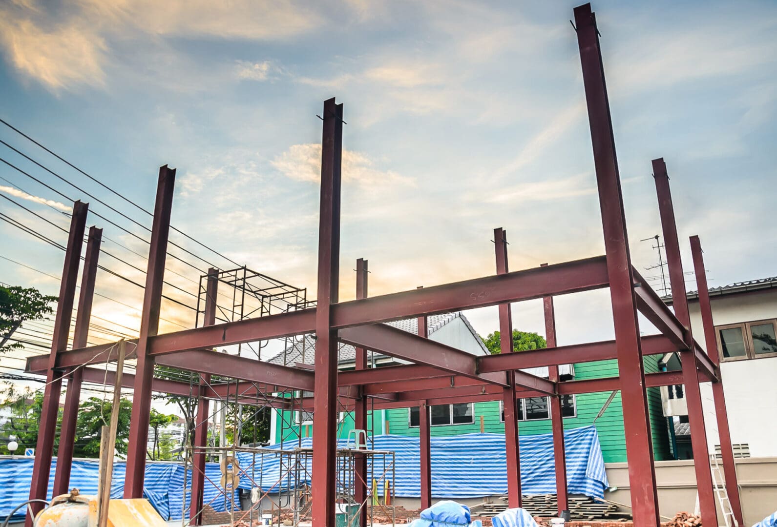 A building under construction with blue tarps around it.