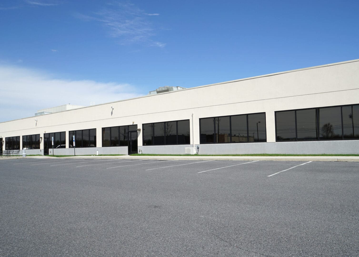 A large building with many windows in the parking lot.