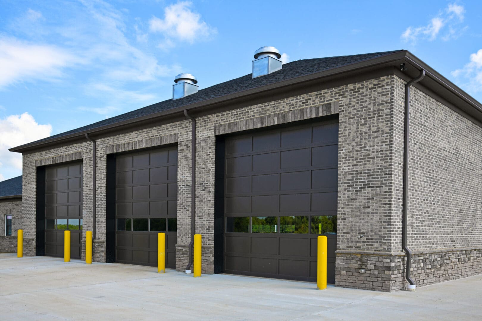 A building with two fire doors and yellow posts.