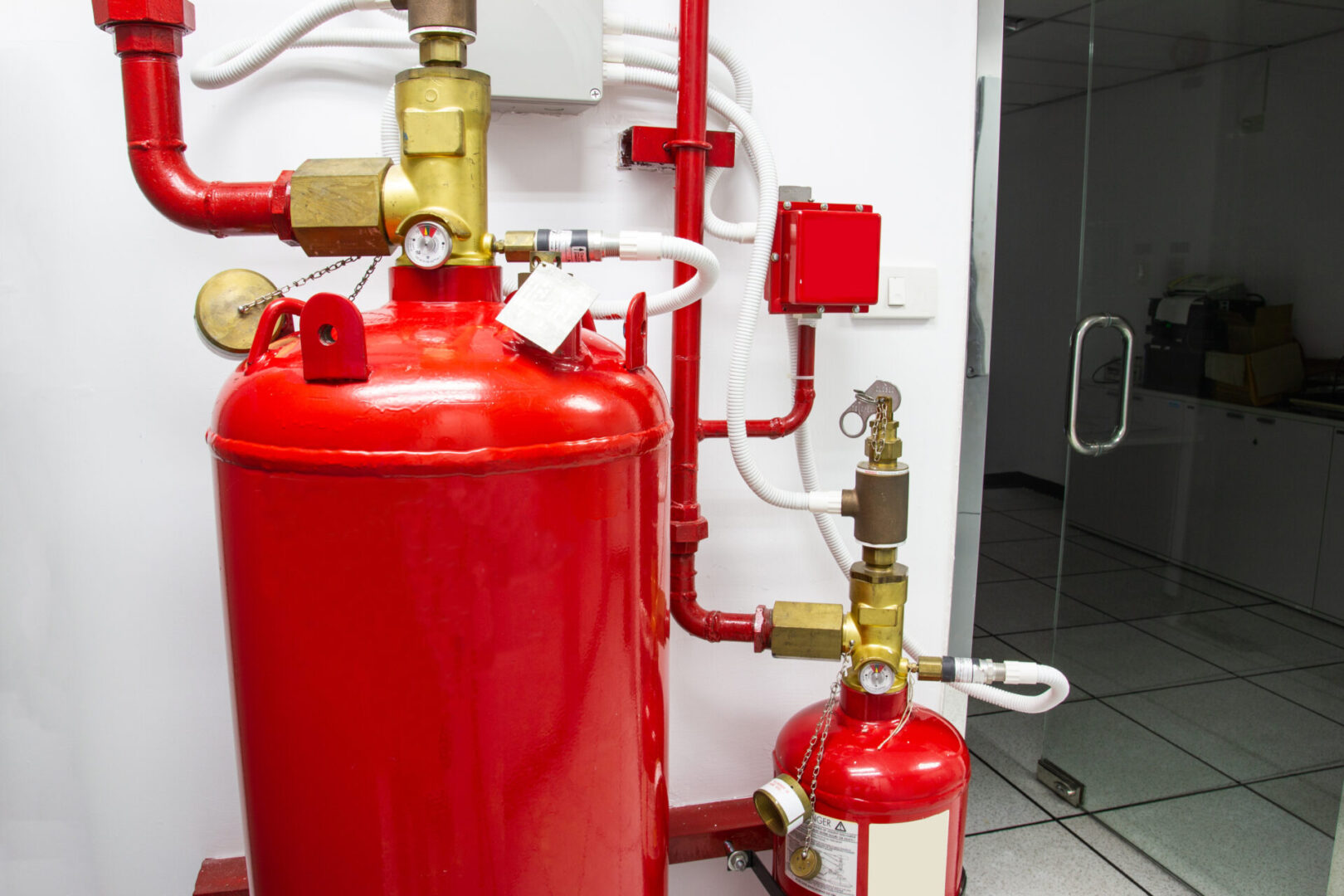 A red fire hydrant and some pipes in a room.