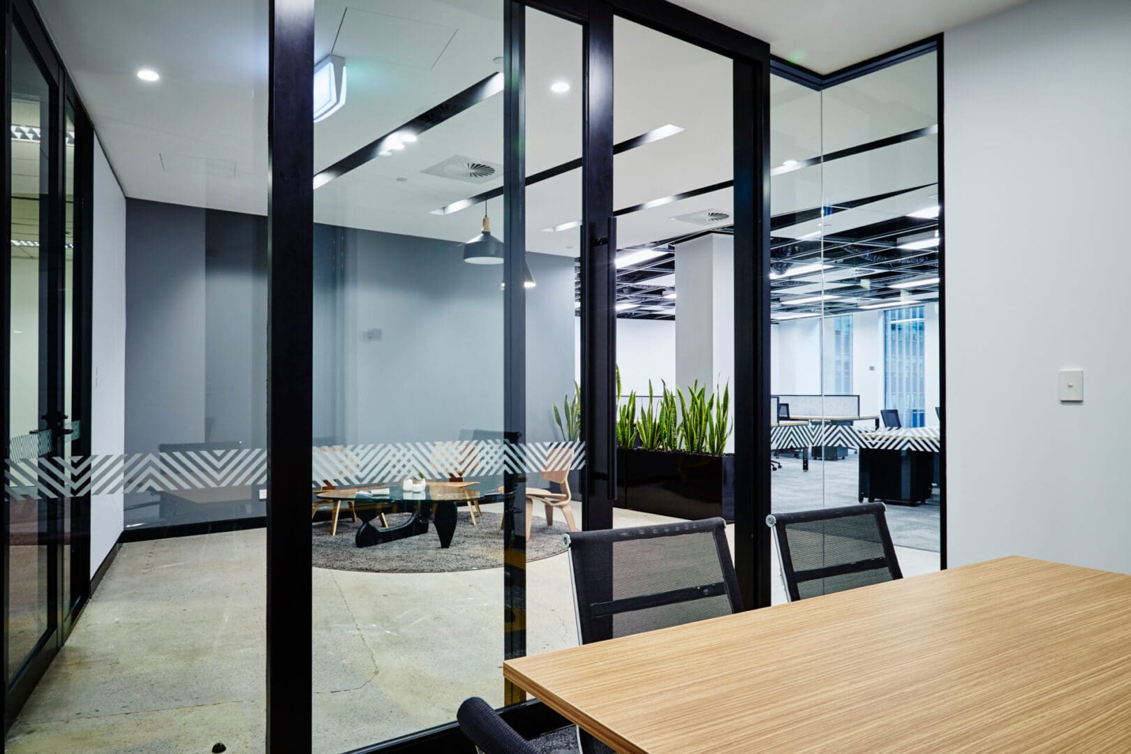 A room with glass walls and wooden tables.