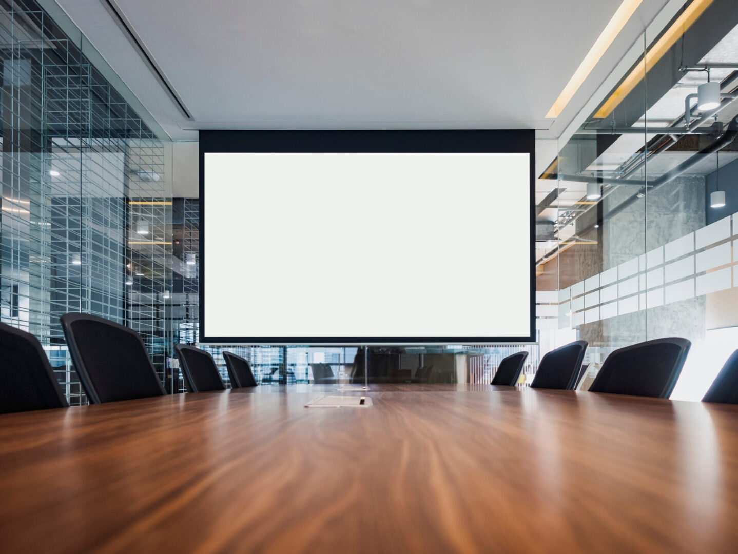 A large screen tv in the middle of a conference room.