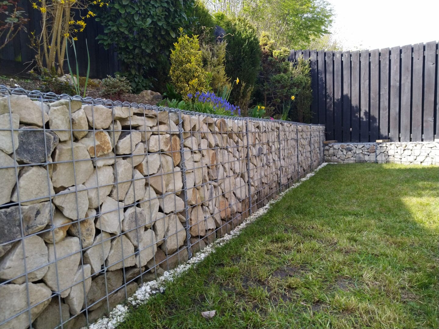 A stone wall with grass in the foreground.