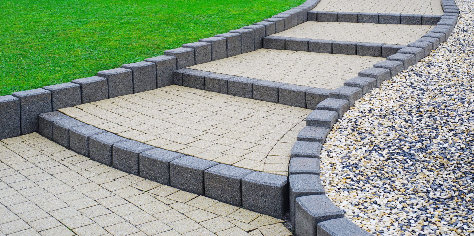 A walkway with stone steps and a lawn.