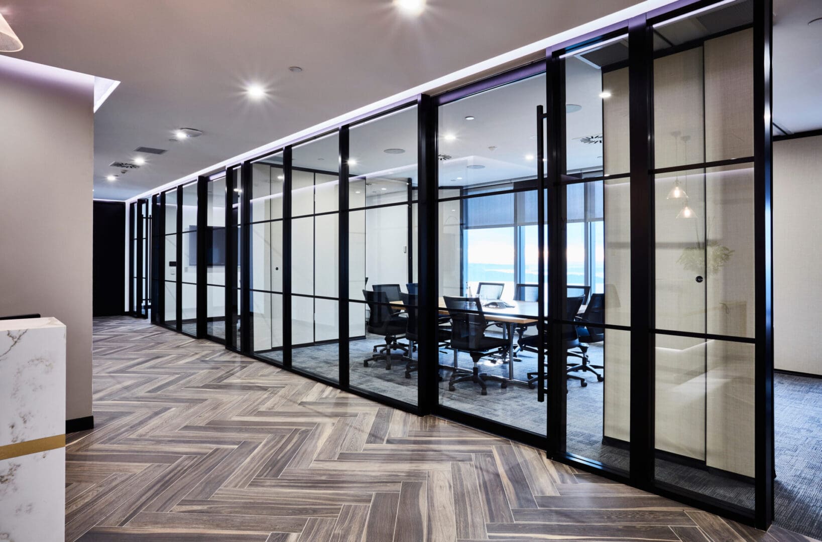 A room with glass walls and black chairs.