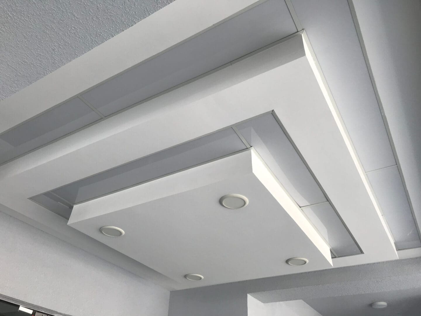 A white ceiling with lights and a beam.