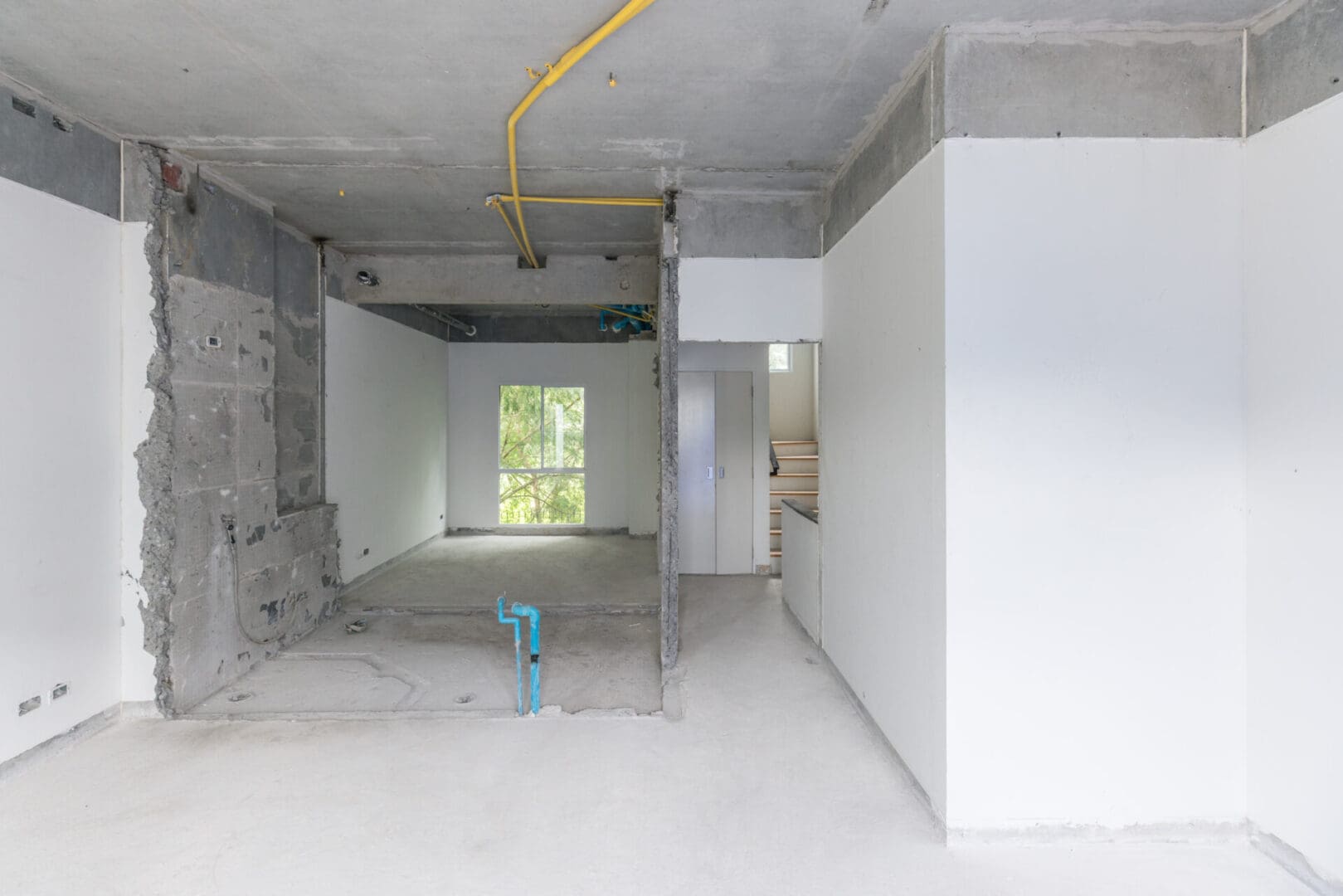 A room with white walls and yellow pipes.