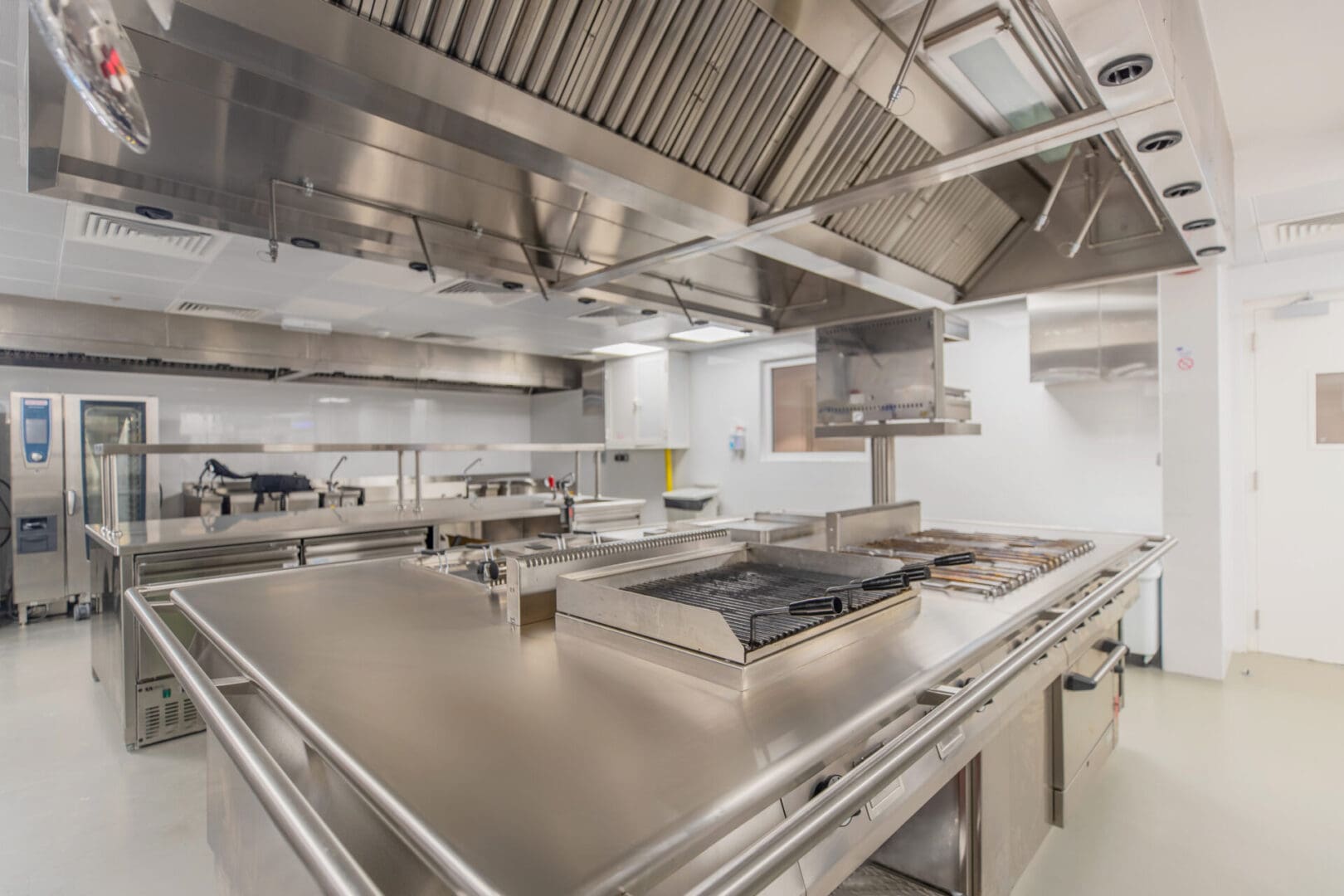 A kitchen with many stainless steel appliances and a large counter.