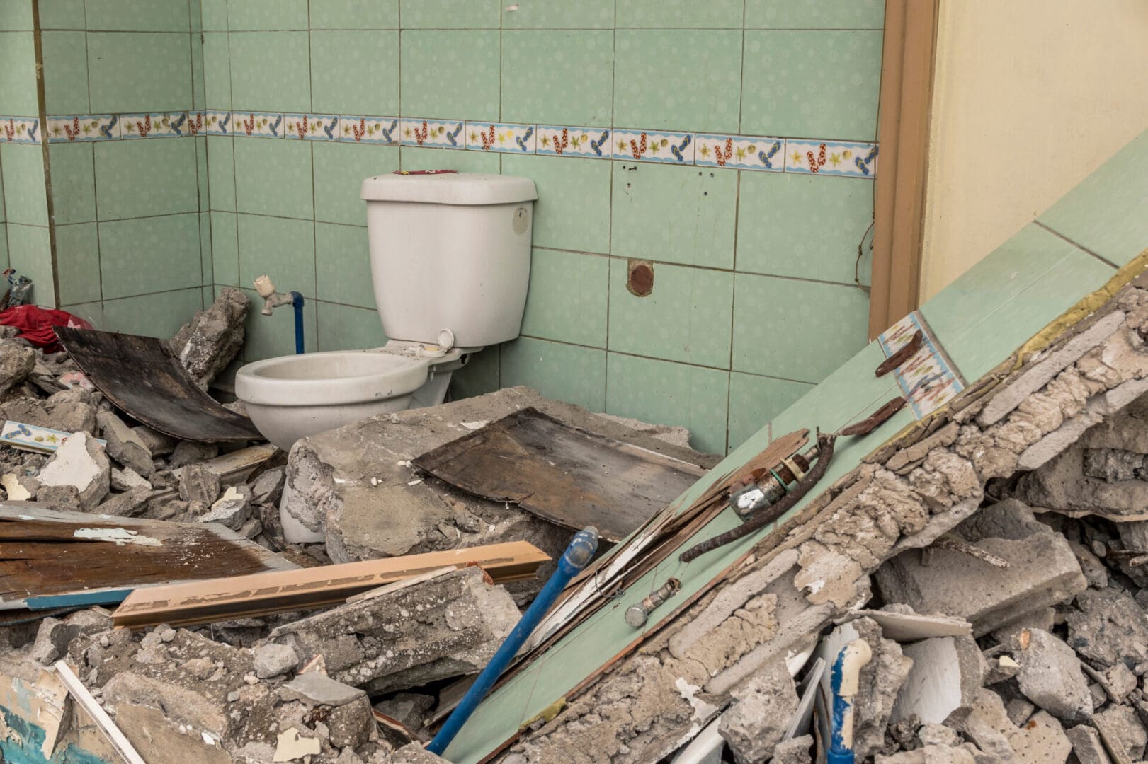 A bathroom with tile walls and floor, toilet and sink.