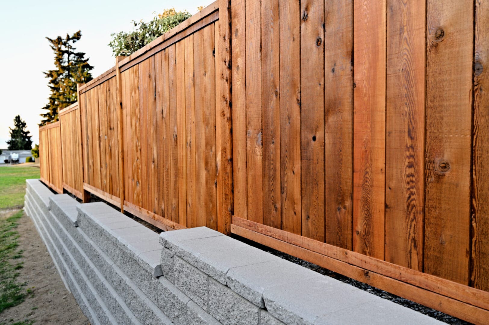 A wooden fence with concrete blocks in the middle of it.
