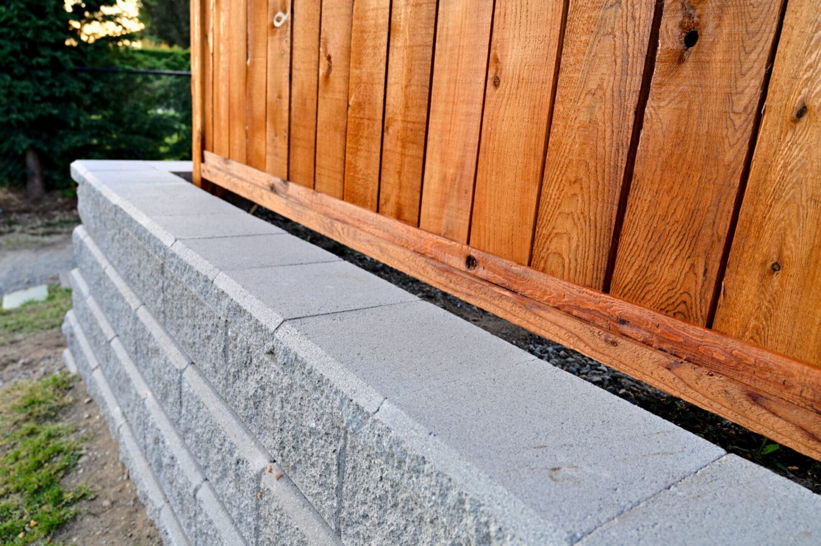A wooden fence with concrete blocks and cement steps.