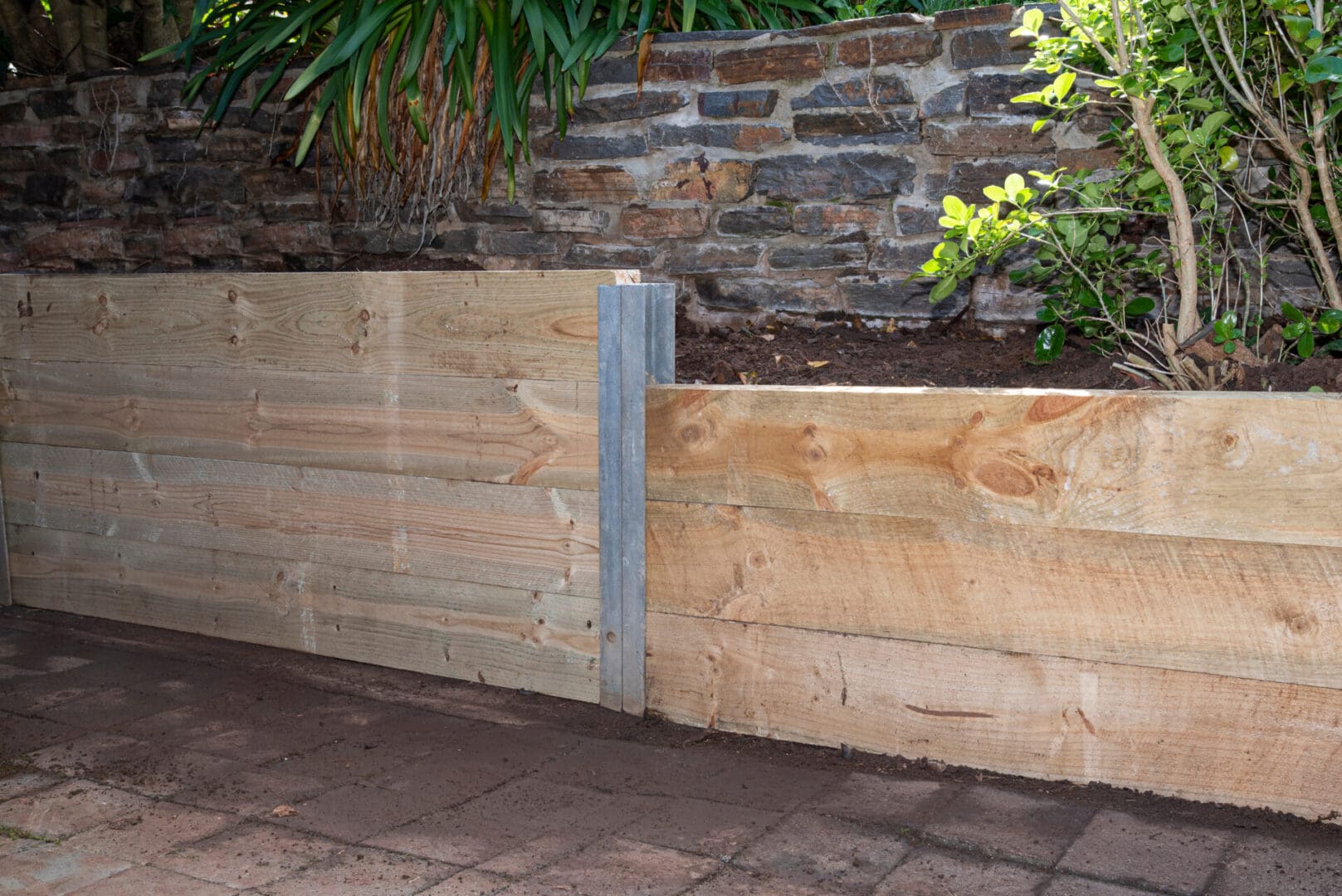 A wooden wall with metal posts on the side.