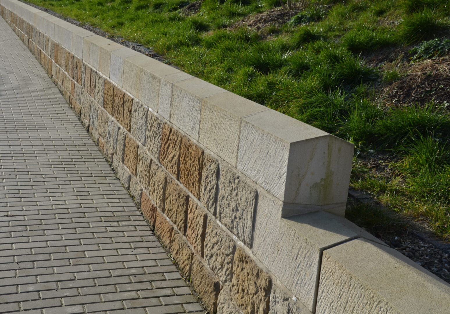 A brick wall with grass in the background