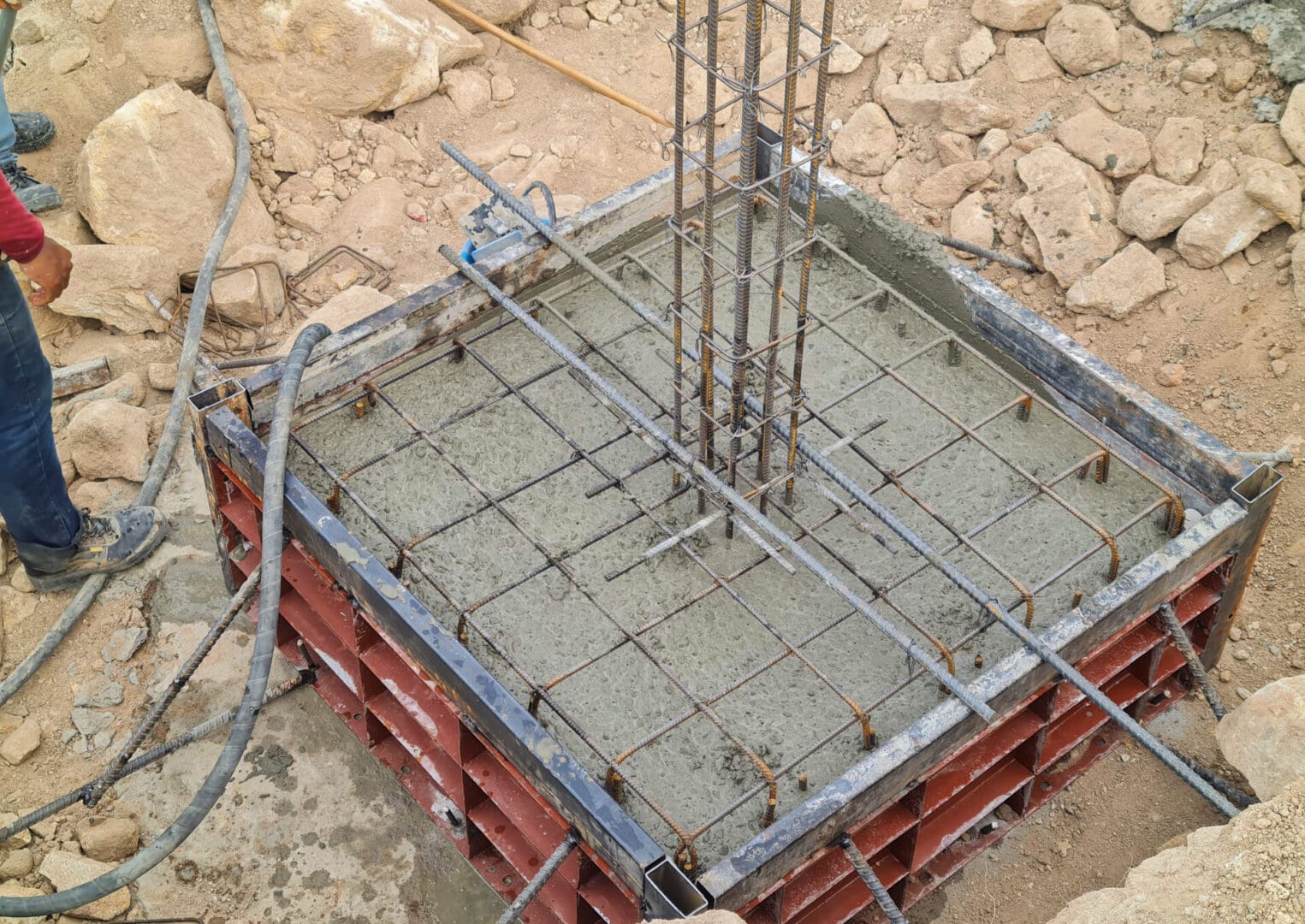 A concrete slab being poured on top of the ground.