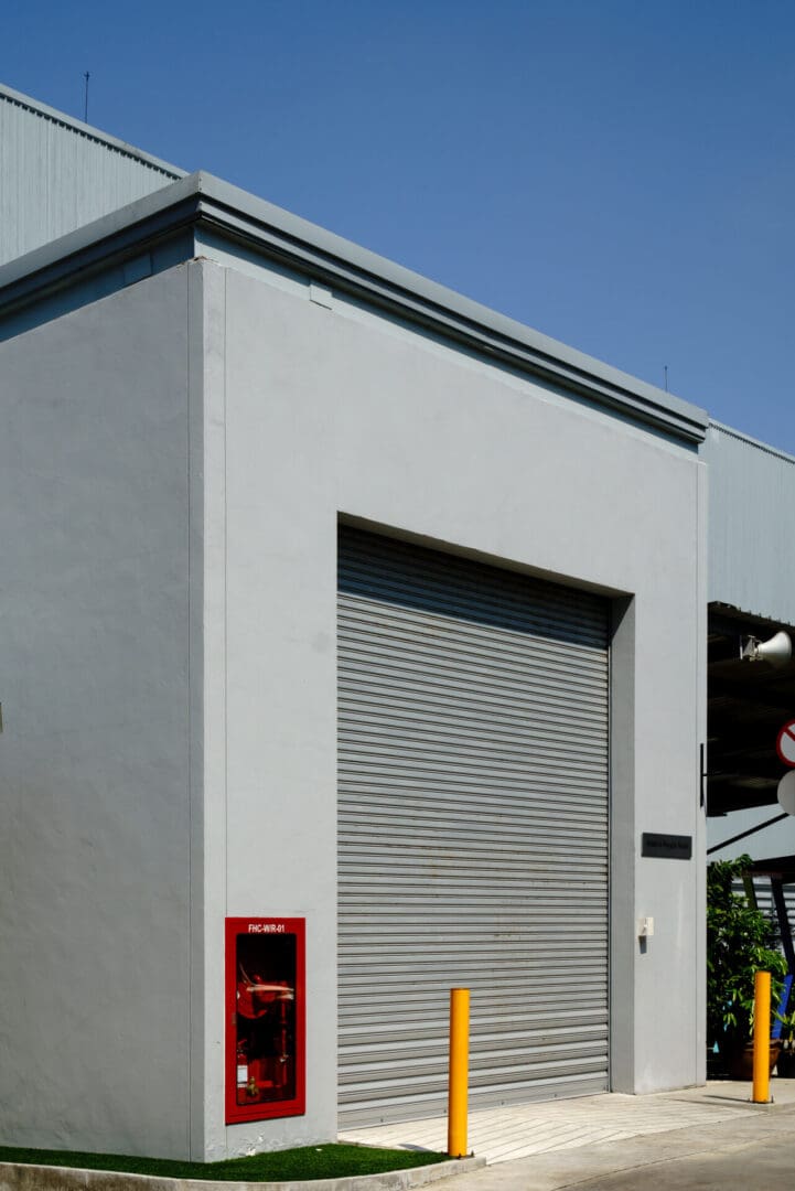 A building with a door open and a fire hydrant on the side.