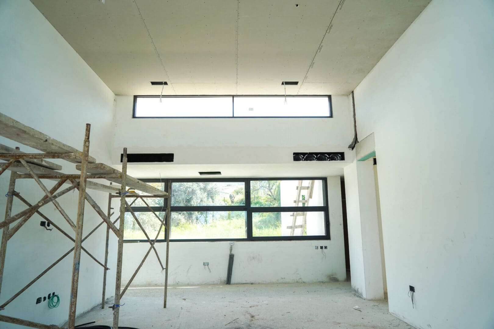 A room with a ladder in it and windows