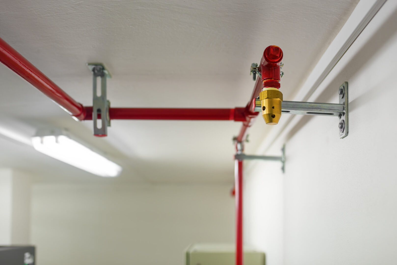 A red pipe hanging from the ceiling of a room.