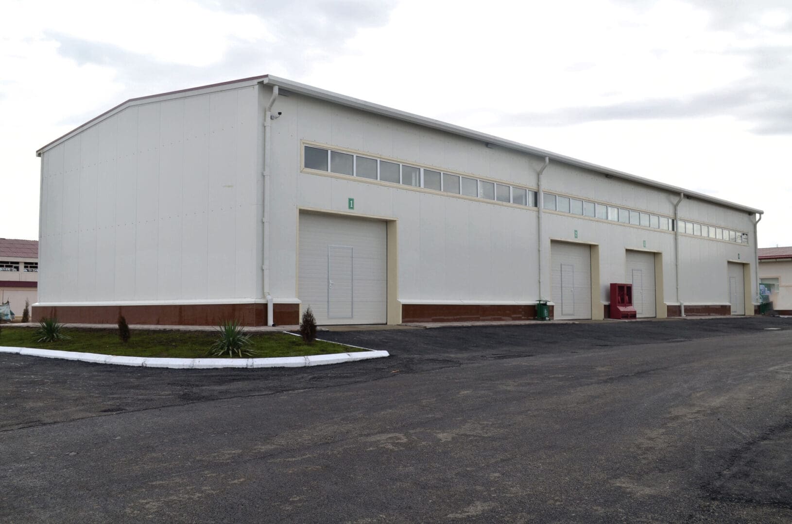 A large white building with two doors on the side.