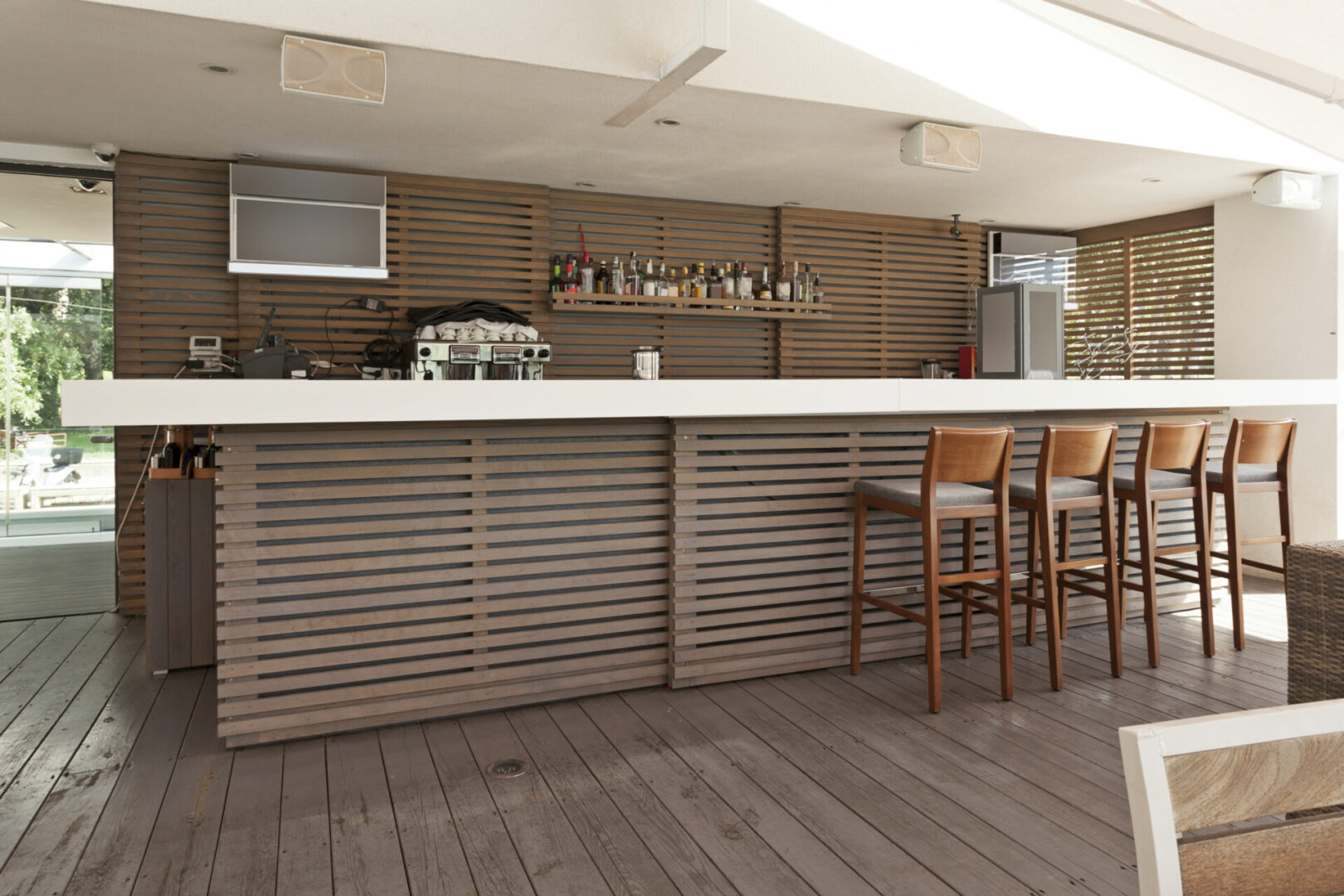 A bar with wooden chairs and a counter.