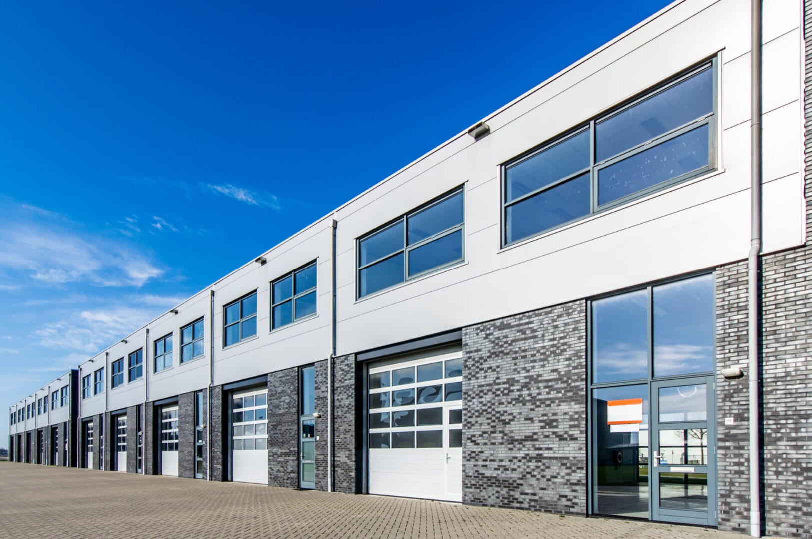 A building with many windows and doors on the side.