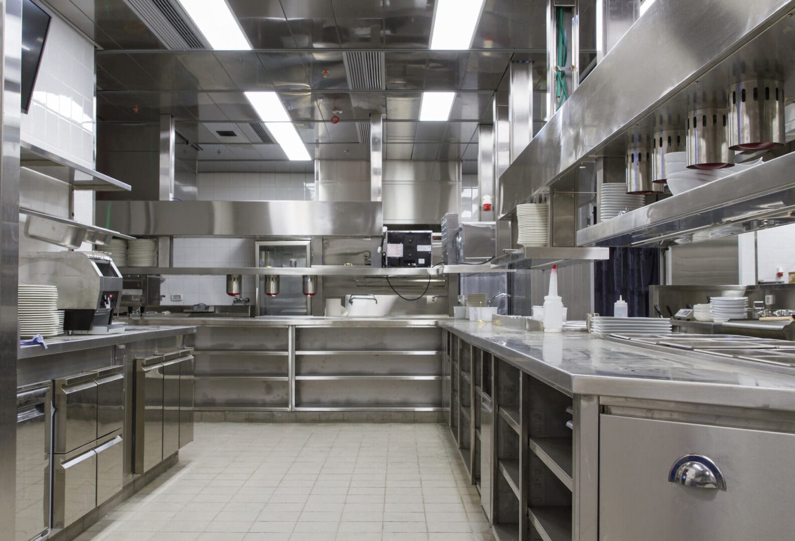 A kitchen with many stainless steel appliances and counters.