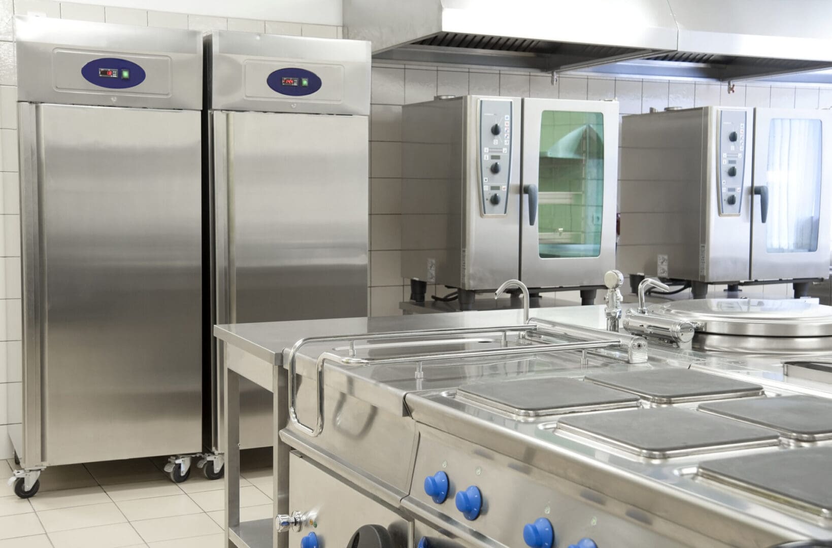 A kitchen with stainless steel appliances and blue knobs.