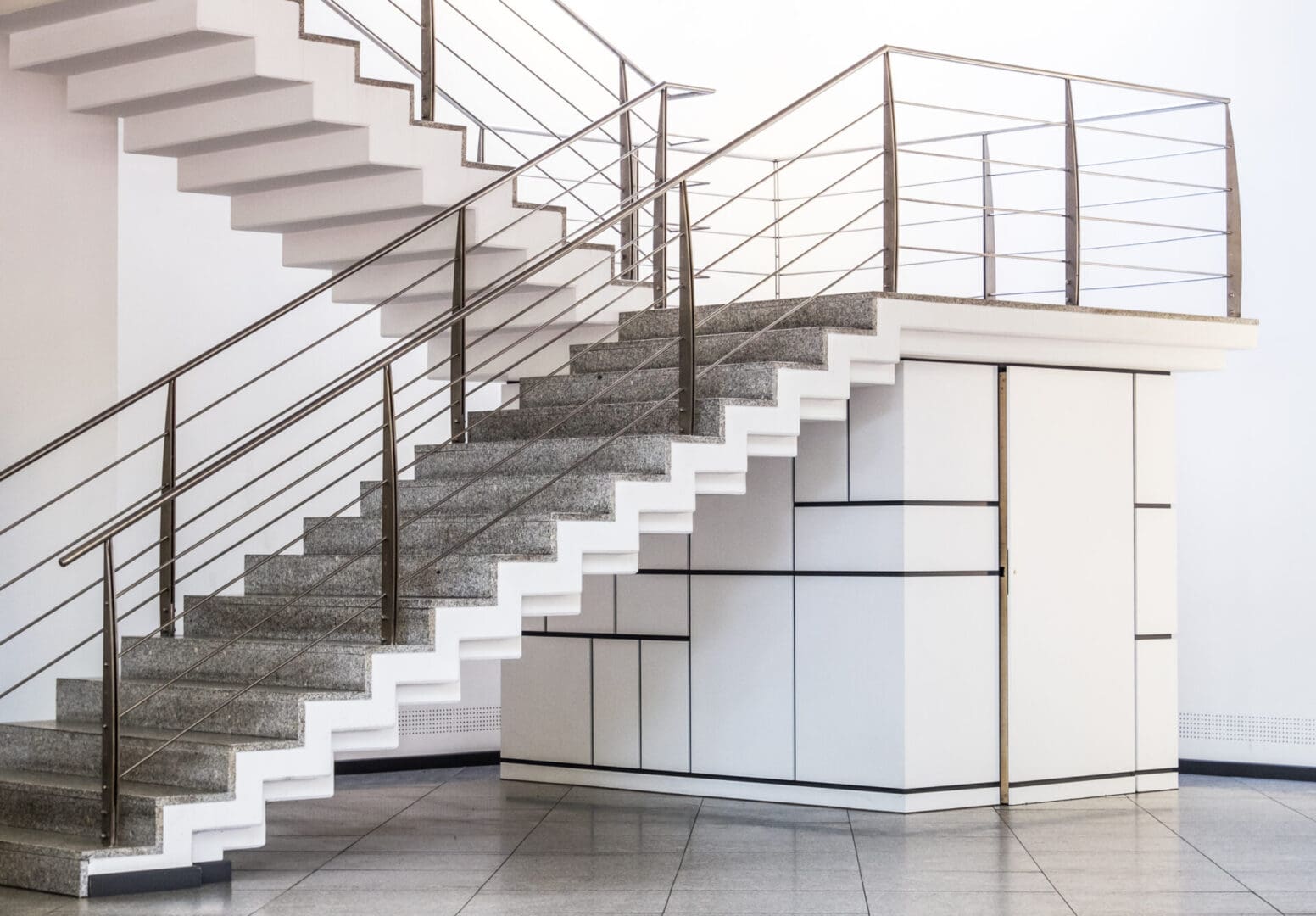 A white staircase with metal railing and steps.