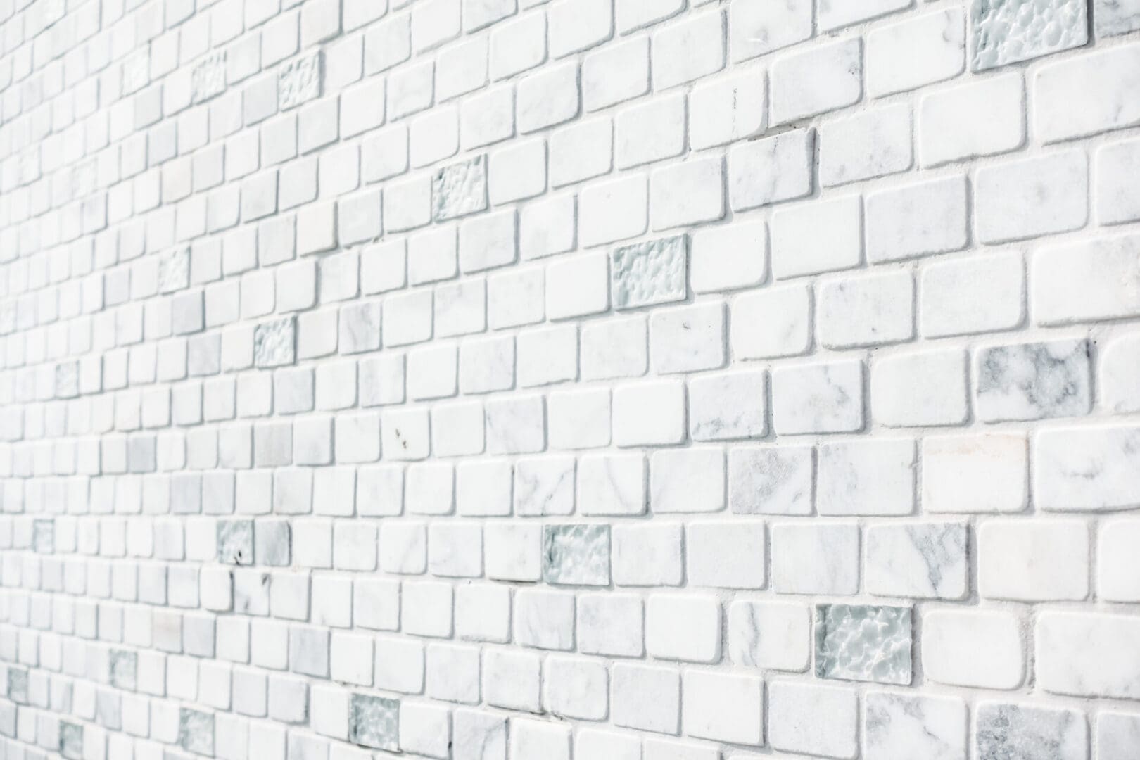 A white brick wall with some small tiles