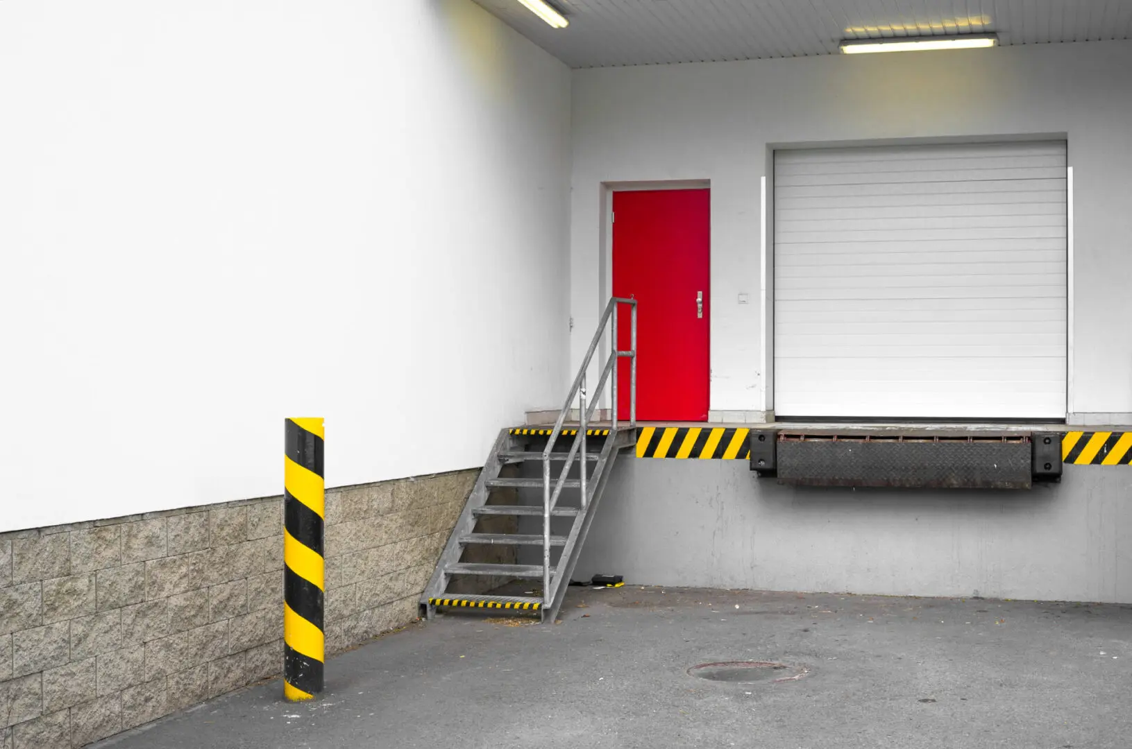 A red door and steps leading to the garage.